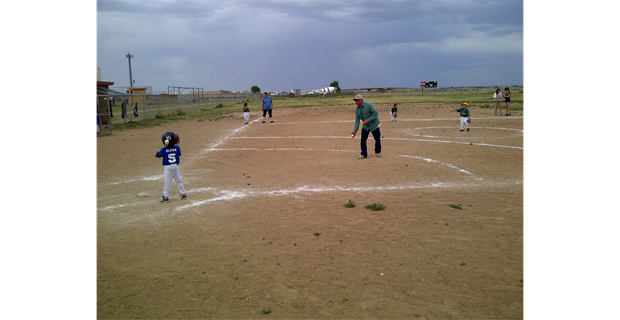 A Lil' Rascal and a coach pitched at bat